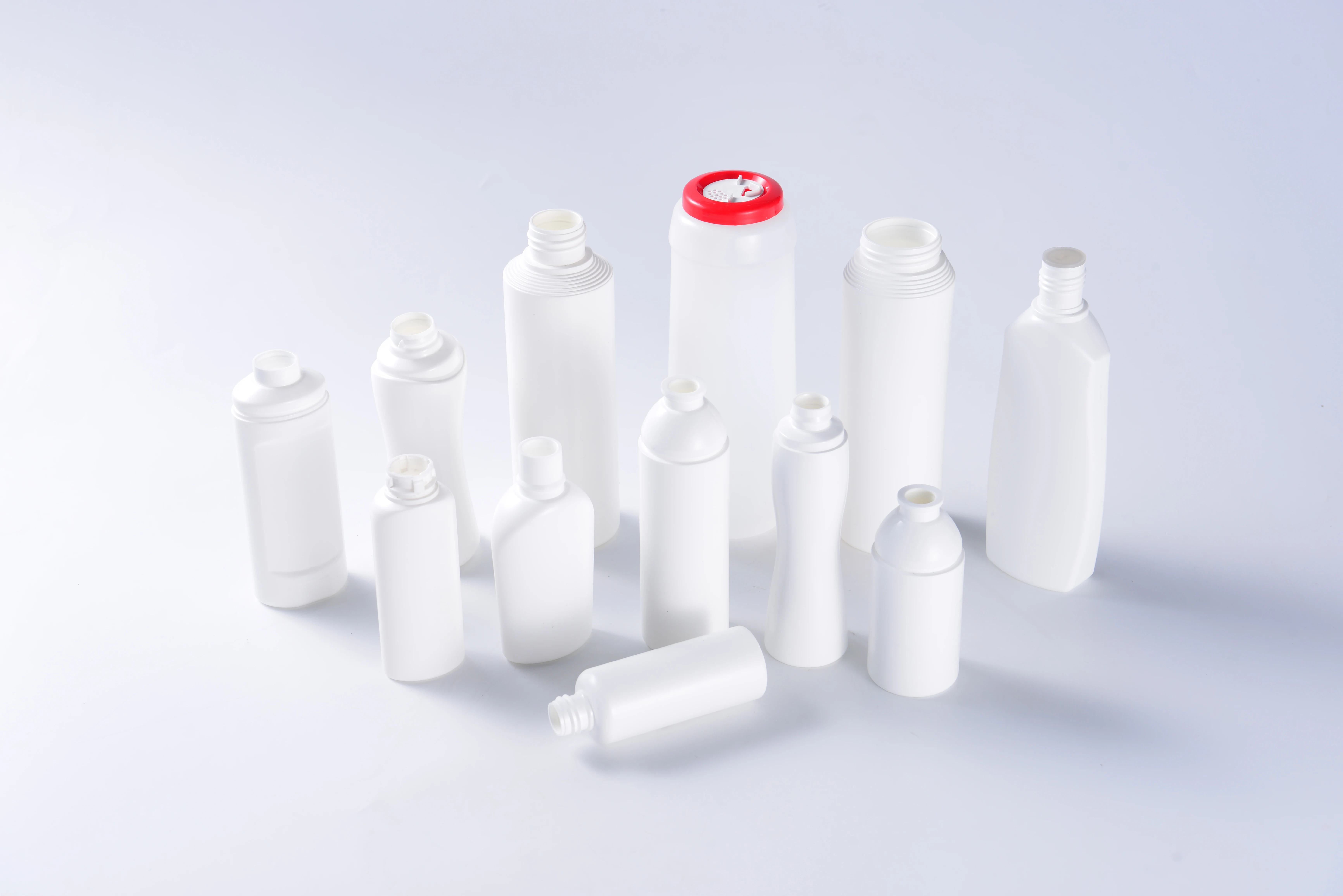 White food and dairy bottle samples in round, tall, flat and shaped formats on a clean background