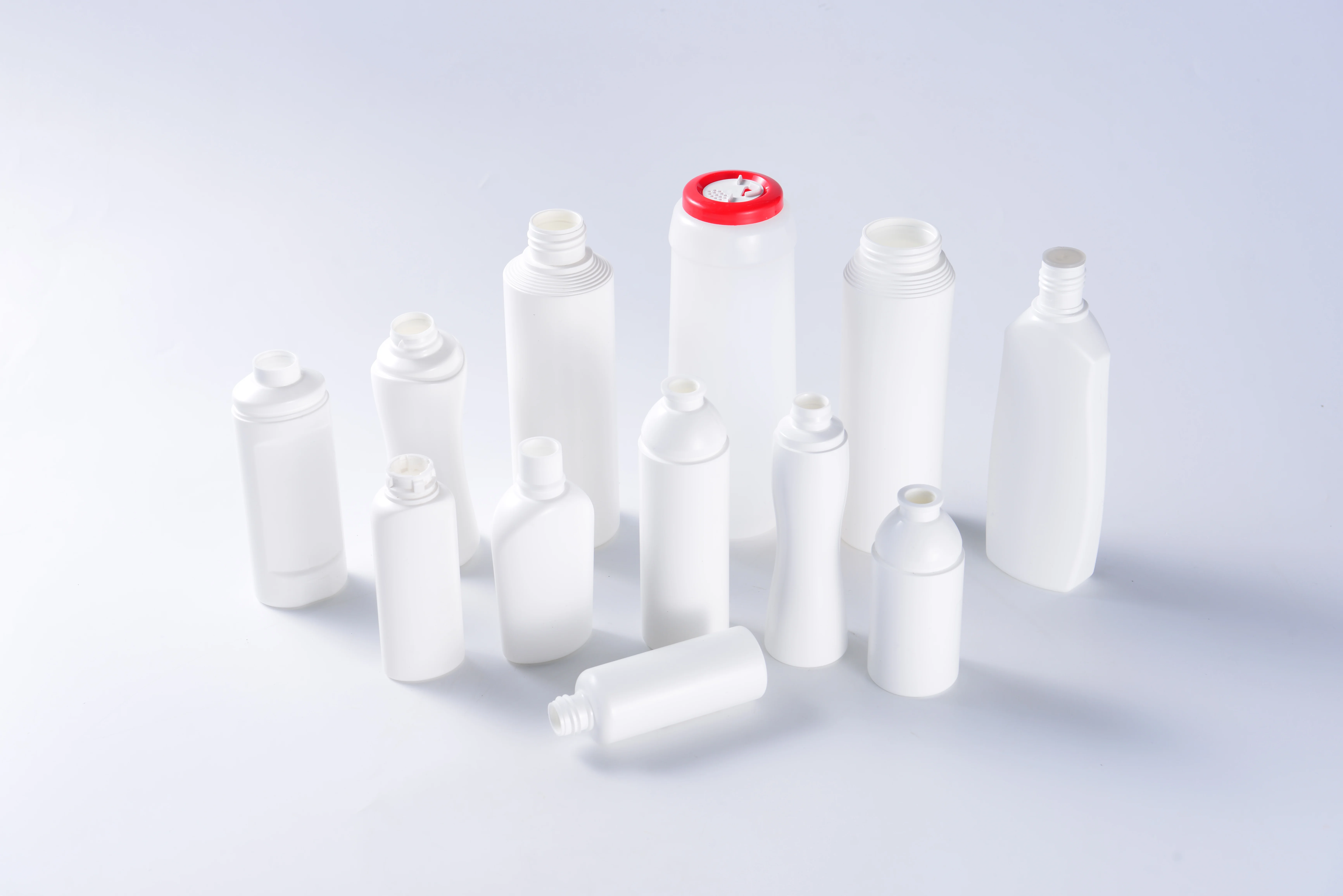 White food and dairy bottle samples in round, tall, flat and shaped formats on a clean background