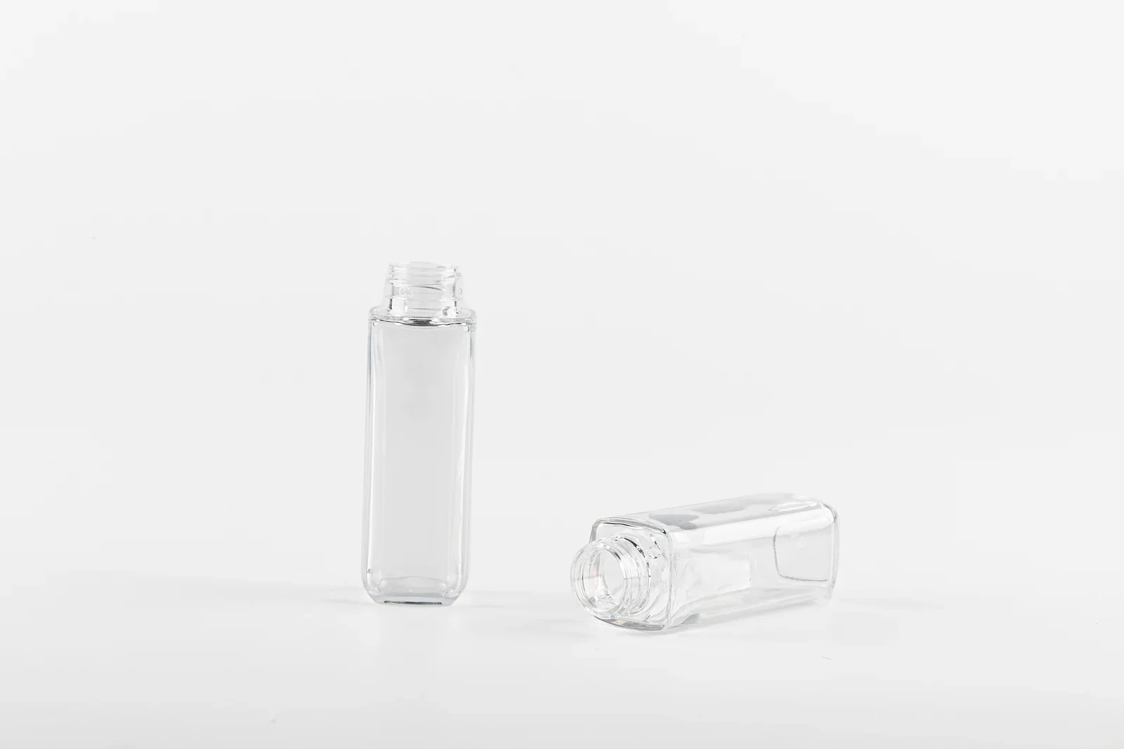 Two clear rectangular cosmetic bottle samples with rounded corners