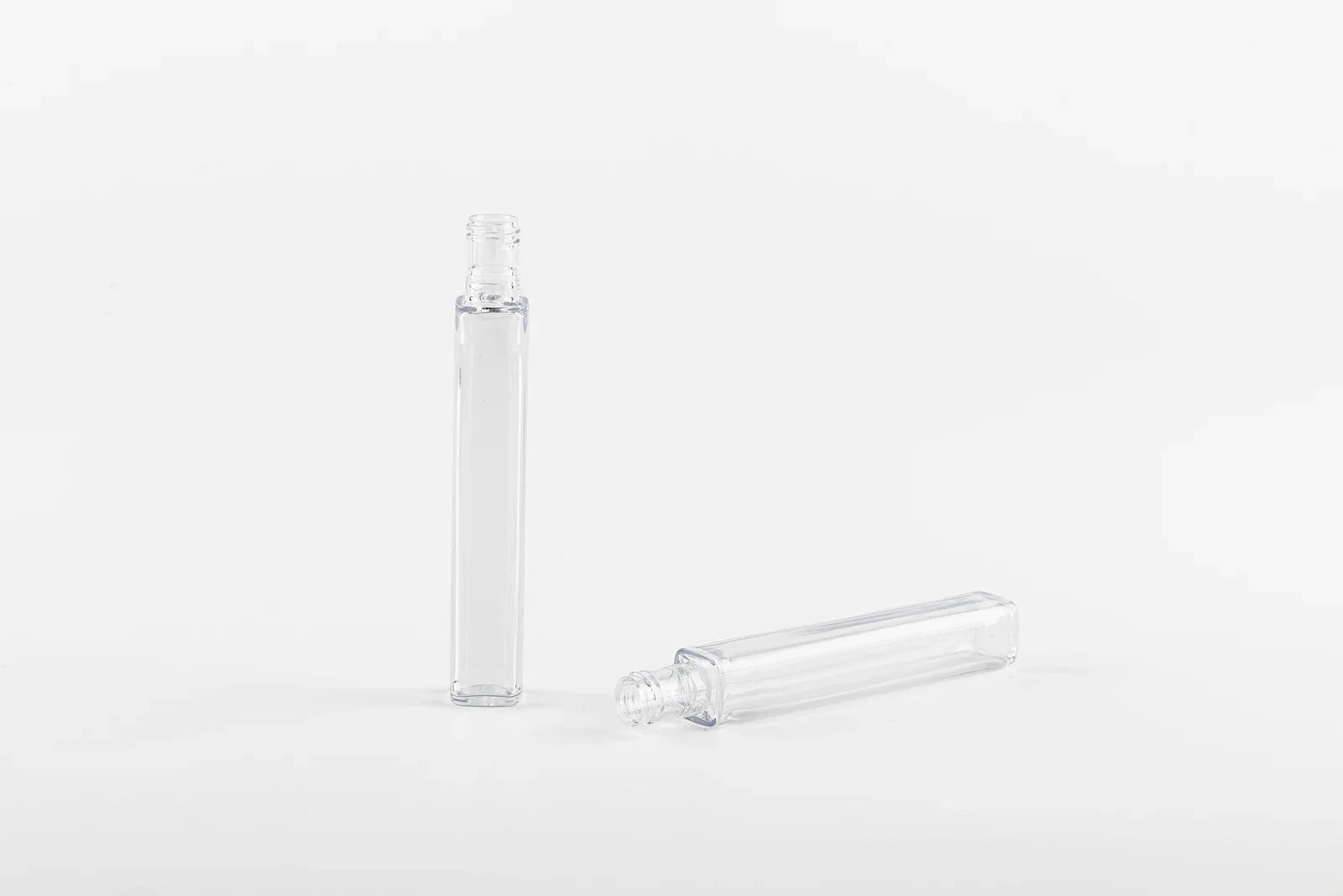Two tall slim clear cosmetic bottle samples with narrow necks