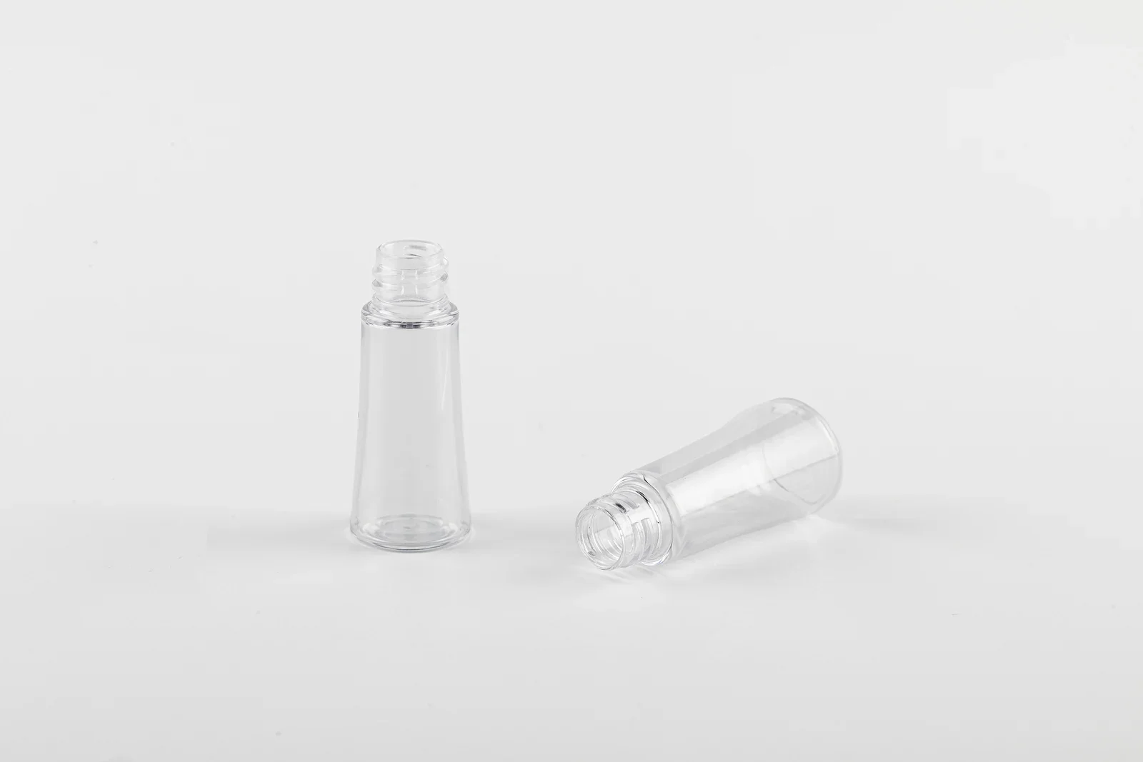 Two clear cosmetic bottle samples with tapered bodies