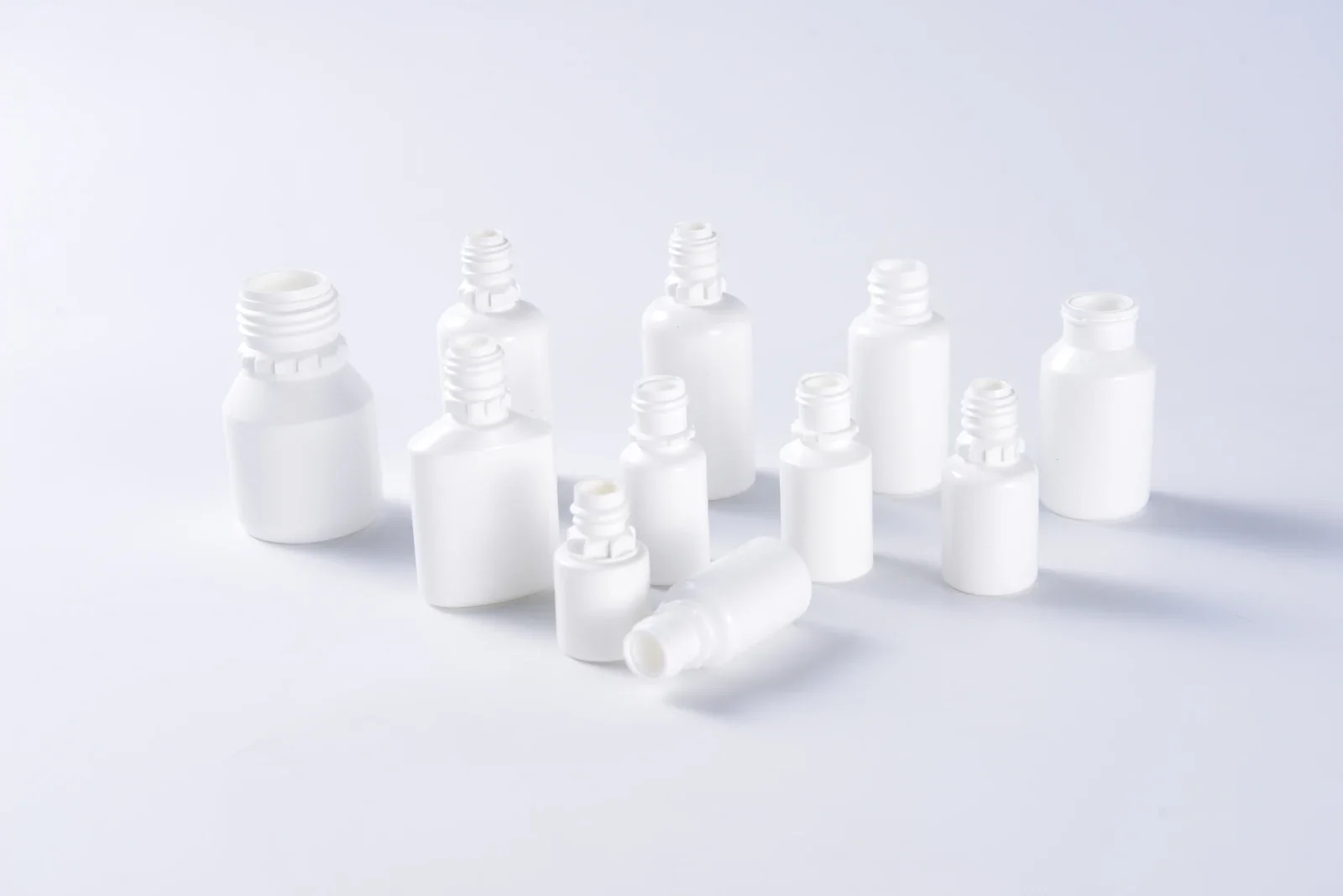 White eye-drop bottle samples with several neck and body shapes