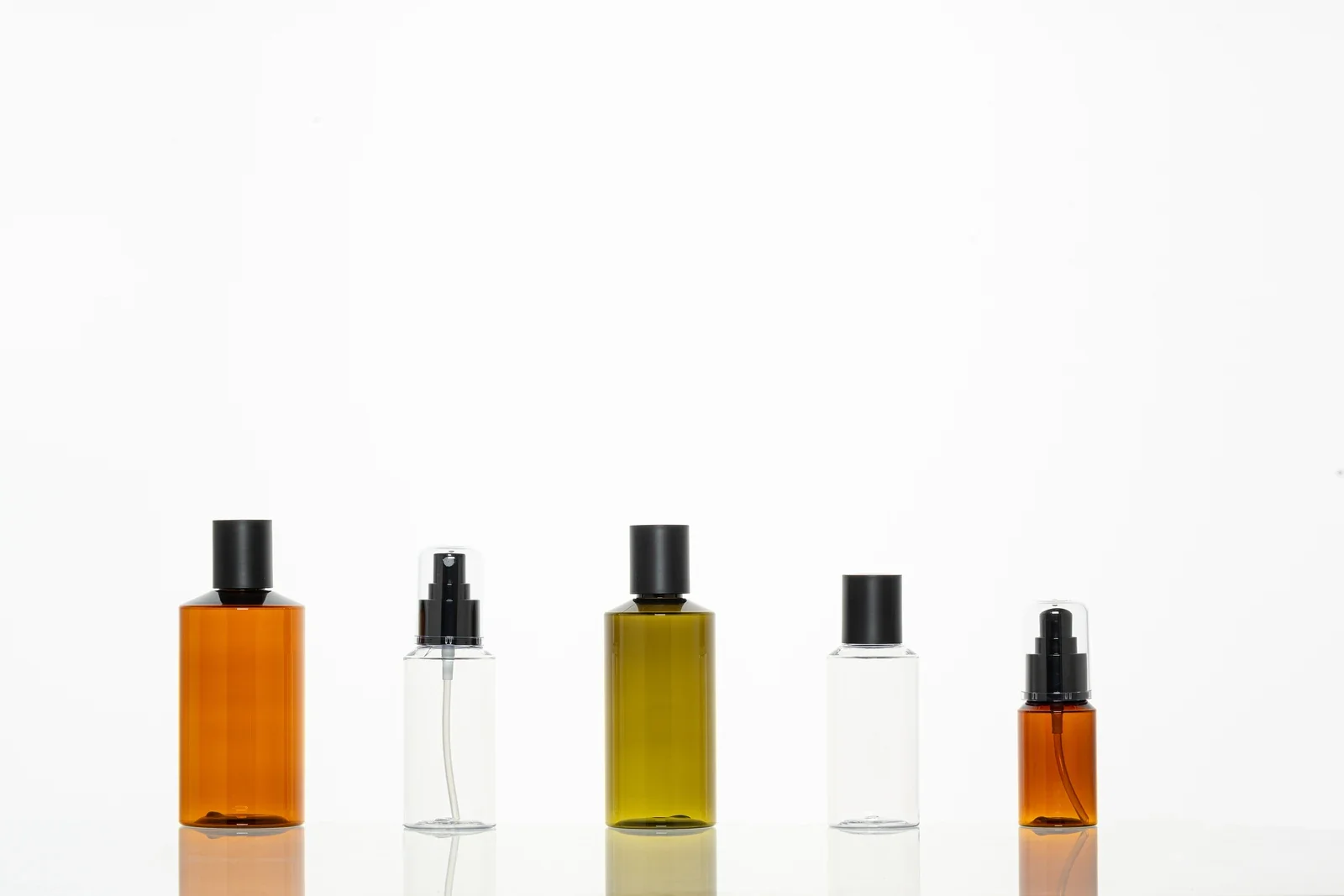 Amber, green and clear cosmetic bottle samples with caps and spray pumps