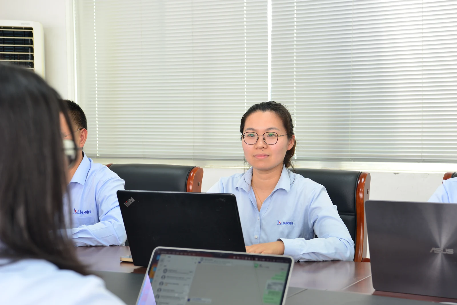 LIANXIN colleagues discussing a project around a meeting table